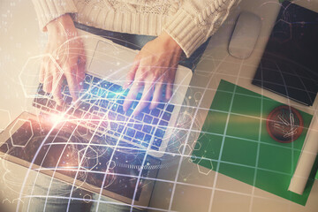 Double exposure of woman hands working on computer and world map hologram drawing. Top View. International business concept.