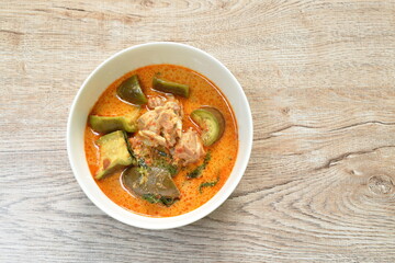 spicy boiled chicken with slice long eggplant in coconut milk green curry soup on bowl