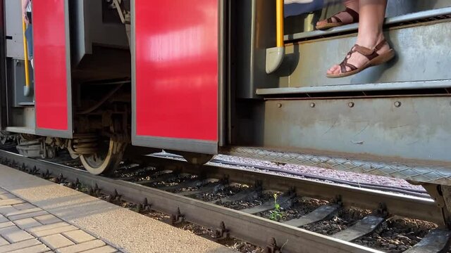 The train opens the doors and passengers get out on the platform 