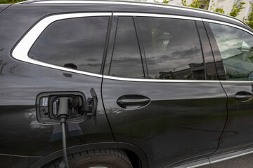 Fototapeta premium Close up view of electric vehicle with charging cable. Sweden. 