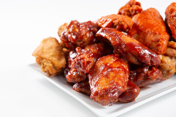 A view of a plate of a chicken wings sampler, featuring flavors as BBQ sauce and buffalo style.