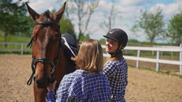two young women in plaid shirts prepare a horse. High-quality photo