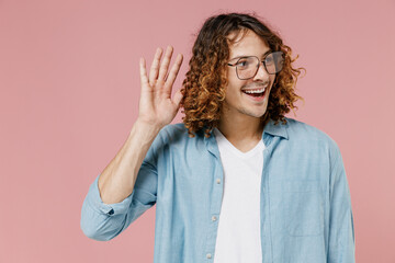 Young smiling curious nosy man 20s with long curly hair wearing blue shirt white t-shirt glasses...