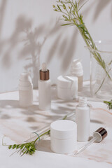 Natural cosmetic products in white packaging with laboratory glassware. Science and skincare concept