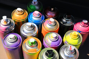 Many different used cans of spray paint, above view. Graffiti supplies