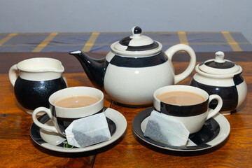 Milk Tea served in a ceramic tea set with tea bags and copy space

