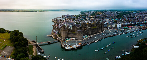 Aerial drone view of Caernarfon castle and battlements along the River Seiont in North Wales