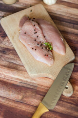 Raw turkey breasts. Lie on a wooden board.All this on a tree background