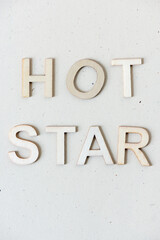 the expression "hot star" in wooden letters on paper