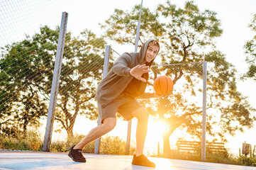 Young positive sunlit sporty smiling sportsman man 20s wear sports clothes hood covering with palms...