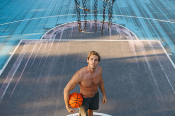 Top view young muscular strong european sportsman man with naked torso scoring basket shoot free...