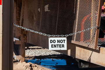 A "Do Not Enter" sign hangs from a chain