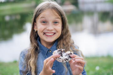 веселая девочка кушает сладости, пончик