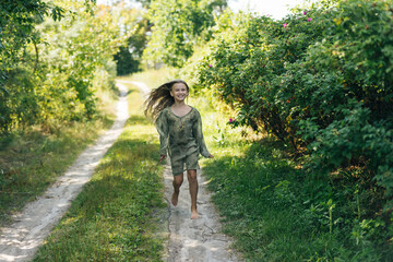 Fototapeta premium beautiful attractive stylish girl in a green dress, with long hair romantic mood, posing in summer fashion style, natural look