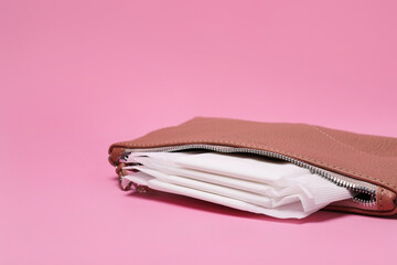 Brown bag with menstrual pads on pink background