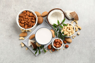 Vegan milk and different nuts on light table, flat lay