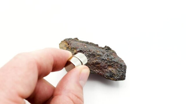 A magnet attracts an iron rock, Ferruginous mass, Iron-rich rock mineral, iron ores, hematite, magnetite, limonite