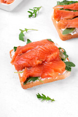 Toast with salted trout, cream cheese and arugula on the white table