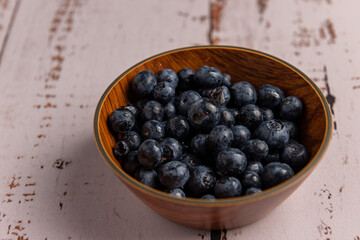 Superalimento orgánico antioxidante de arándanos, en un recipiente sobre una mesa de madera 