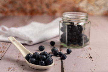 Superalimento orgánico antioxidante de arándanos, en un recipiente sobre una mesa de madera 