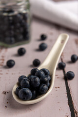 Superalimento orgánico antioxidante de arándanos, en un recipiente sobre una mesa de madera 