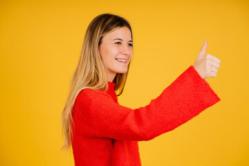 Young woman showing thumb up to someone.