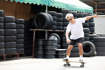 young man skater riding on skateboard at tires automobile store © offsuperphoto