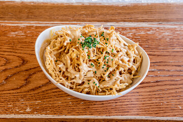 Panko tempura straw fries with chopped chives in a white bowl