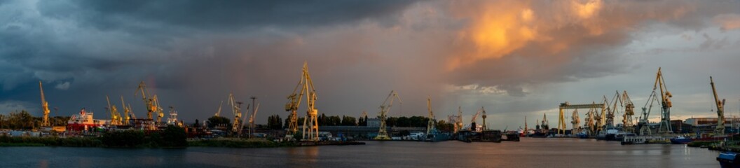Panoramic view of Szczecin shipyards during a passing evening storm - obrazy, fototapety, plakaty