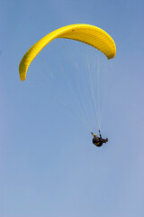 Paraglider flying at a clear blue sky a sunny day