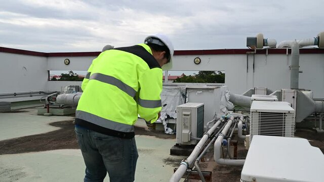 Air conditioning technicians repair and maintain condensing units outside the building, engineers inspect the operation of ventilation fans.