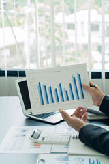 A financial businessman and calculator calculates and analyzes graphs on real estate investment...
