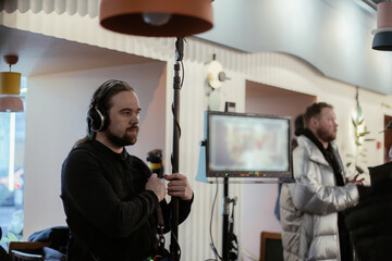 Sound engineer with a microphone on the set. A professional sound engineer at work on the filming...