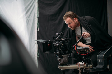 Director of photography with a camera in his hands on the set. Professional videographer at work on filming a movie