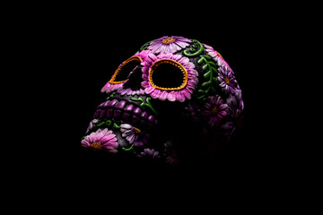 Typical Mexican skull with flowers painted on black background