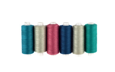 Top view of spools of colored thread on a white background.