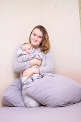 Fototapeta na wymiar home photos of a young mother with a small child. Newborn boy. Cute, cozy photos with a baby.