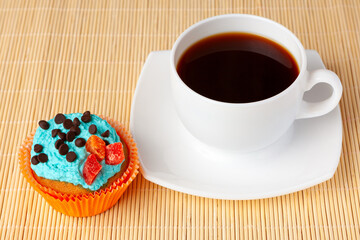 Cup of coffee and cupcake with cream and chocolate drops,