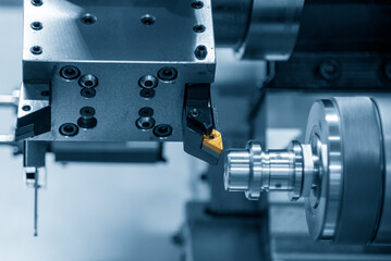 The chip insert cutting tool of CNC lathe machine cutting the metal shaft parts . © Pixel_B