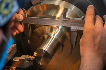 The machine operator use Vernier caliper measure brass material parts .