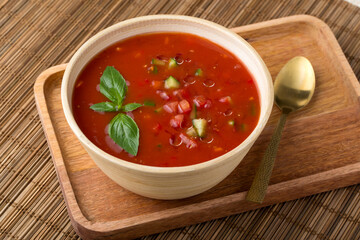 Gazpacho in bowl on wooden tray with spoon