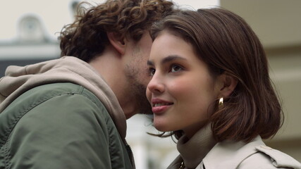 love couple feeling happy outdoor. Man whispering to woman ear on urban street. - obrazy, fototapety, plakaty