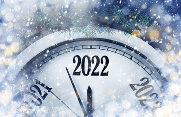 Fototapeta na wymiar Clock counting last moments to New 2022 Year and beautiful fir branches. Bokeh effect