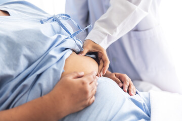 Blurred soft images of woman doctor using a hand to hold the belly fat Of obese woman patients, who...