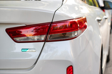 Closeup of car tail light on a white car.