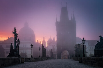 Charles bridge in Prague at foggy morning in Czech Republic.