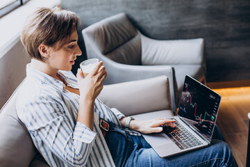 Woman working on exchange and watching rise and fall of graphics