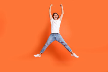 Fototapeta na wymiar Full body photo of happy cheerful crazy man jump up winner celebrate hooray isolated on orange color background