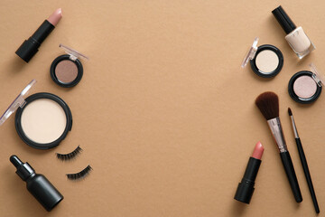 Flat lay set of professional makeup cosmetics and tools on brown background with copy space. Beauty...