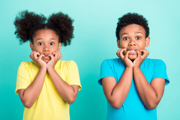 Photo of scared brunet little girl boy bite fingers wear t-shirt isolated on teal color background